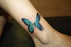 Tatuaje de una mariposa volando por el tobillo