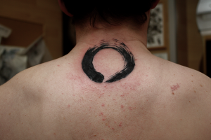 Tatuaje de un circulo zen en la nuca
