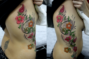 Tatuaje de flores en el costado de una chica