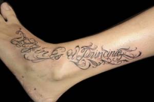 Tatuaje de la frase El fin es mi principio en el tovillo