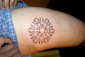 Tatuaje de un copo de nieve en la pierna
