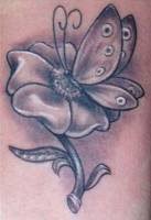 Tattoo de una mariposa posada en una flor