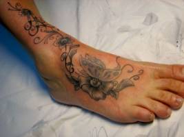 Tattoo de flores en el pie con una mariposa