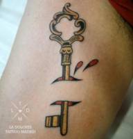 Tatuaje de una llave atravesando la piel
