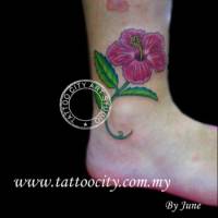 Tatuaje de una flor con hojas en el tobillo