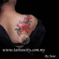 Tatuaje de una rama con flores cruzando la clavícula de una chica