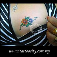 Tatuaje de una pequeña flor en el pecho de una chica