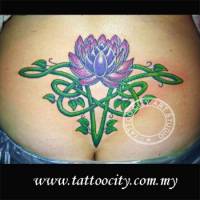 Tatuaje de una flor de loto con una planta de forma céltica encima del culo de una chica