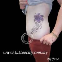 Tatuaje de una flor de tallo fino con estrellas en el costado de una mujer