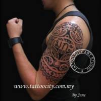 Tatuaje de estética maorí con unas letras tailandesas enmedio