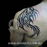 Tatuaje de una cola de dragón en forma de tribal