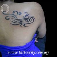 Tatuaje de un ave fenix tribal en la espalda de una mujer