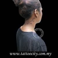 Tatuaje de una frase con algunos pájaros en el cuello