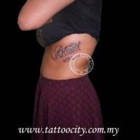Tatuaje de la palabra Blessed en el costado de una mujer