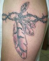 Tatuaje de un brazalete de espinos con plumas indias