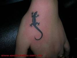 Tattoo de un lagarto subiendo la mano