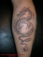 Tatuaje de un dragón saliendo de una bola de puas
