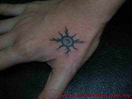 Tatuaje de un pequeño sol en la mano
