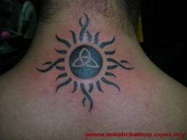 Tatuaje de un sol con un símbolo celta en la nuca