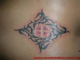 Tatuaje de una cruz con un símbolo tribal