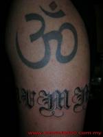 Tatuaje del Om y un nombre como brazalete del brazo