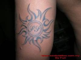 Tatuaje de un sol con iniciales dentro