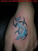 Tatuaje de un delfín en la mano, entre tribales