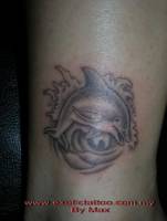 Tatuaje de un delfín en untre olas