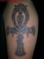 Tatuaje de una cruz ansada egipcia con una gárgola dentro y un ojo de horus encima
