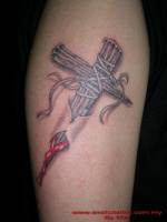 Tatuaje de una cruz de maderas afiladas atravesando la piel