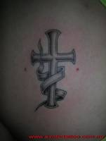 Tatuaje de una cruz con una etiqueta rodeandola