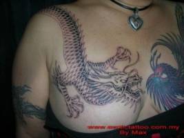 Tatuaje de un gran dragón y un fénix, encarados en el pecho de una mujer