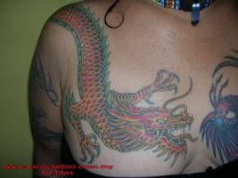 Tatuaje de un dragón a color en el pecho de una mujer