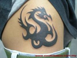 Tatuaje de un dragón tribal en la cadera de una chica