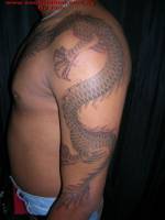 Tatuaje de un gran dragón recorriendo el brazo