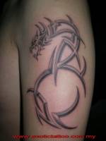 Tatuaje de un dragón  con el cuerpo a base de tribales