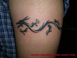 Tattoo de un pequeño dragón rodeando el brazo