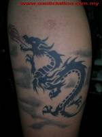 Tatuaje de un dragón surcando los cielos y lanzando una bola de fuego