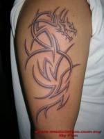 Tattoo de un dragón a base de tribales en el brazo