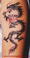 Tatuaje de una sombra de dragón sacando fuego rojo