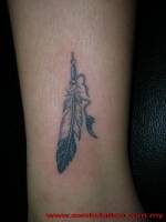 Tatuaje de una pluma india en la pierna