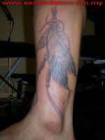 Tatuaje de unas plumas indias en la pierna