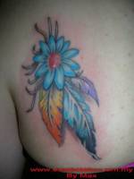 Tatuaje de una flor con varias plumas colgando