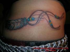Tatuaje de un colgante indio con una pluma