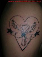 Tatuaje de una corazón con una cigüeña y una etiqueta