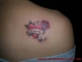 Tatuaje de un corazón con una rosa y una etiqueta
