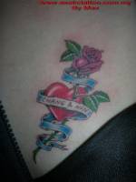 Tatuaje de un corazón atravesado por una rosa, con una etiqueta 
