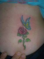 Tatuaje de una mariposa volando hacia una rosa