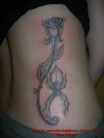 Tatuaje de una rosa con una araña colgada