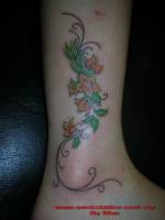 Tatuaje de una planta enredada en la pierna